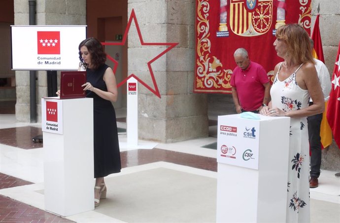 La presidenta de la Comunidad de Madrid, Isabel Díaz Ayuso (i), durante la firma con los sindicatos del borrador del decreto que regulará las condiciones que regirán el teletrabajo en el ámbito de los empleados públicos de la Administración.