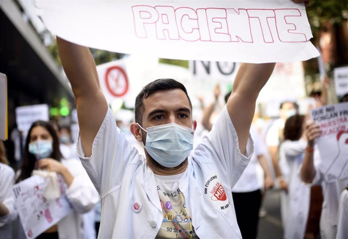 Un médico residente de la Comunidad de Madrid levanta una pancarta en la que se lee 'paciente' durante una manifestación, hoy lunes, justo cuando se cumple una semana de huelga indefinida, para reclamar un convenio colectivo ante la negativa de la Conse
