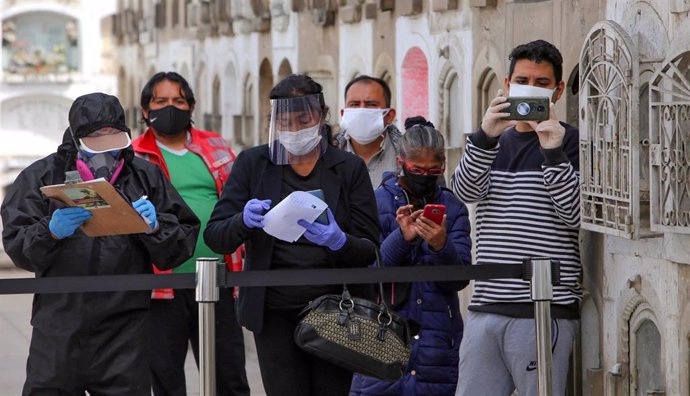 Varias personas con mascarilla en un funeral en Perú en plena pandemia del coronavirus. 
