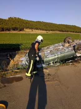 Un bombero trabaja junto al vehículo que ha sufrido un accidente en Falces.