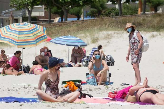 Varias personas protegidas con mascarillas toman el sol en la Playa de A Rapadoira en Foz, en la comarca de A Mariña, Lugo, Galicia (España), a 9 de julio de 2020. El pasado 5 de julio la Xunta ordenó el cierre hasta mañana 10 de julio de los accesos de