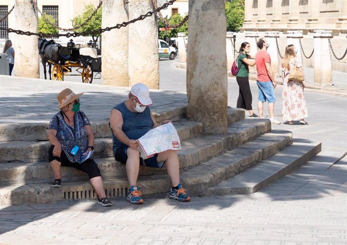 Unos turistas en los alrededores de la Catedral   en el primer día  de uso obligatorio de mascarillas en Sevilla a 15 de julio del 2020