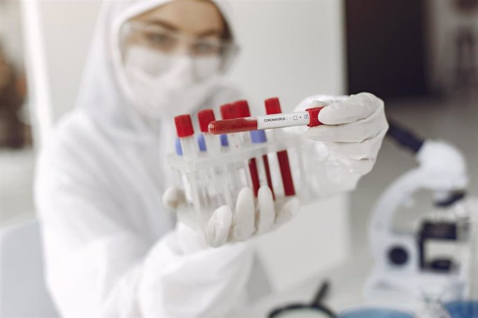 Imagen de recurso en la que se aprecia a una investigadora mostrando pruebas de muestras de coronavirus.