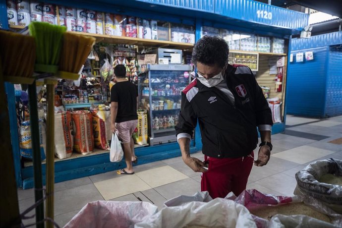 Un hombre con mascarilla por el coronavirus en un mercado en Lima.
