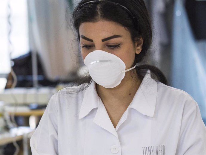 A seamster gathers up medical face masks to place in a package at the Tony Ward Couture fashion house on March 26, 2020 in Beirut, Lebanon.