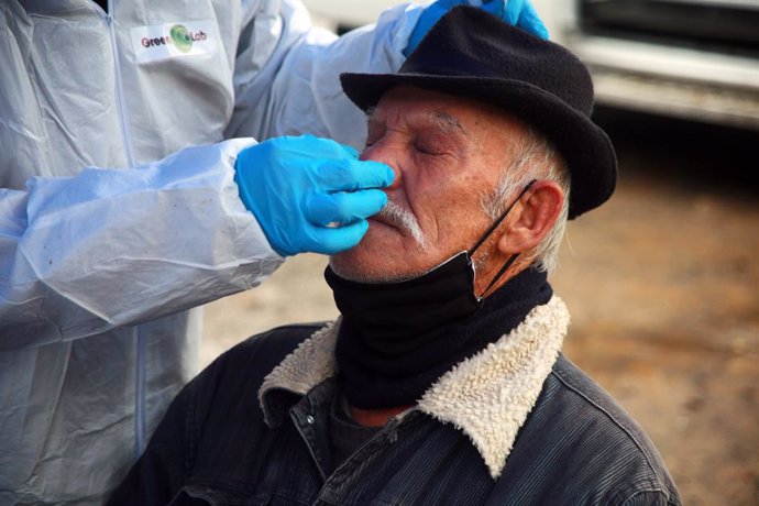 A health worker takes a sample from a man at a rapid corona test station following the Chilean government decision to extend the strict exit restrictions to contain the spread of the coronavirus pandemic