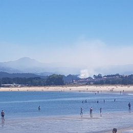 Vista del incendio originado en Gondomar desde una playa de Nigrán (Pontevedra)