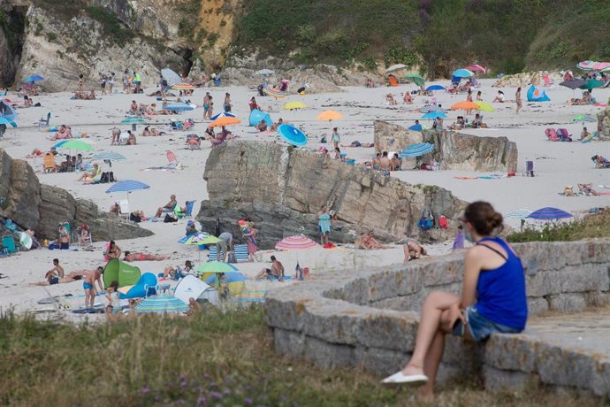 Una persona sentada frente a la playa en A Mariña (Lugo/Galicia) a 27 de julio de 2020. La comarca mantiene este domingo 51 casos activos de COVID-19 tras una nueva alta y un nuevo contagio con respecto al sábado.