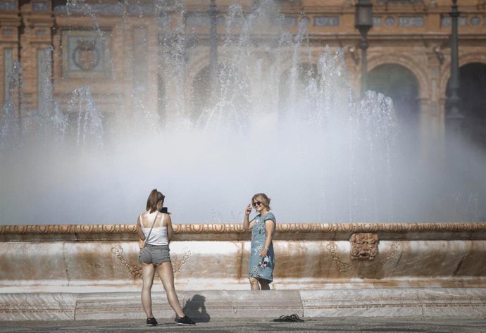 Una mujer posa para una foto dentro de la fuente de Plaza de España, en Sevilla