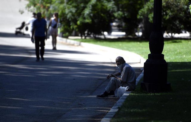 Un hombre se sienta a la sombra en el Parque del Retiro en Madrid