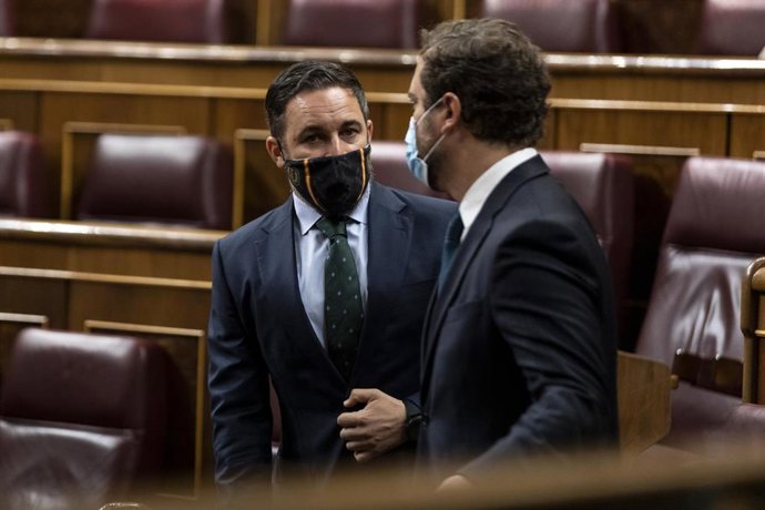 El presidente y el portavoz de Vox, Santiago Abascal e Iván Espinosa de los Monteros, charlan antes del inicio de una sesión plenaria.