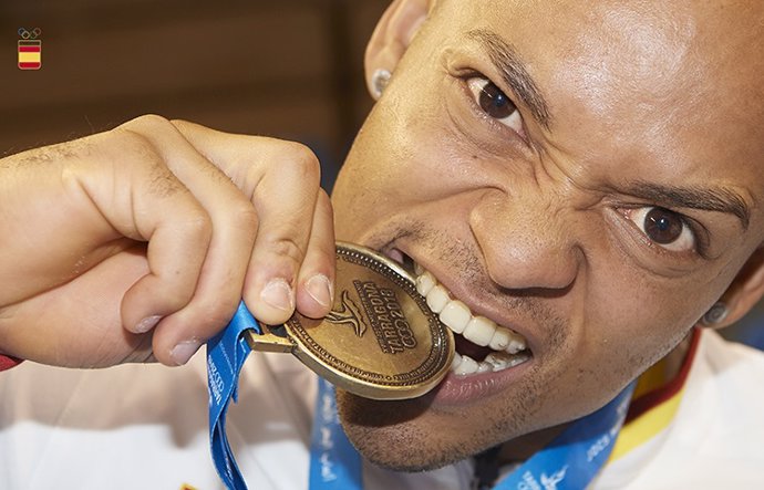 El gimnasta español de origen dominicano Ray Zapata muerde su medalla en los Juegos Mediterráneos de Almería 2018