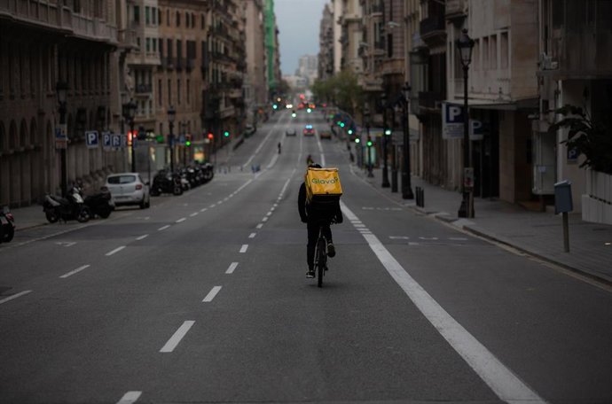Un trabajador de Glovo en bicicleta por una calle, en Barcelona/Catalunya (España) a 23 de marzo de 2020.