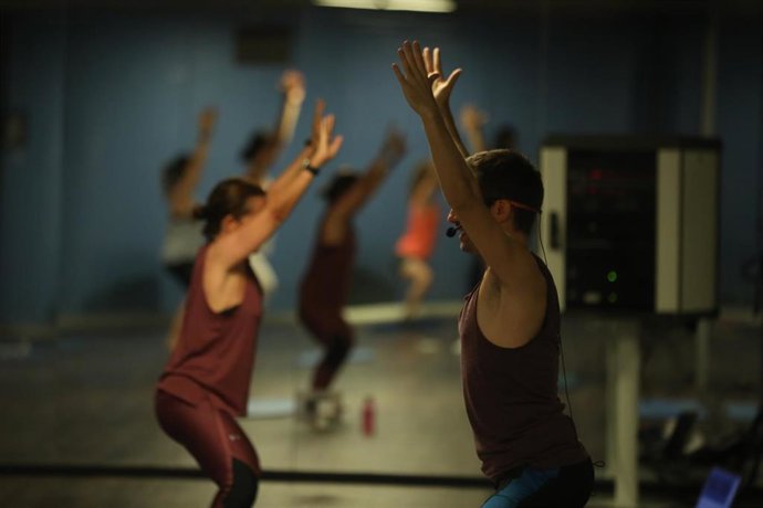 Un entrenador imparte clase a varias personas en una clase de Body Balance en un gimnasio, a 26 de junio de 2020. 