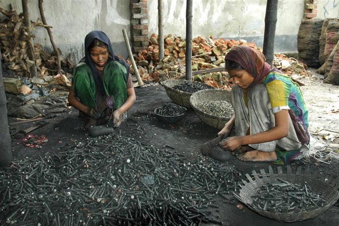 Unas niñas de 12 y 18 años trabajando con material tóxico en una calle de Bangladesh