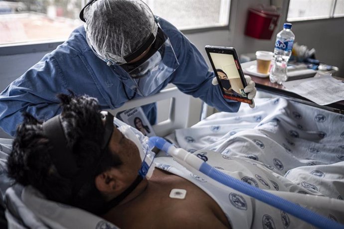 Un médico sostiene un móvil para que un paciente de COVID-19 pueda hacer una videollamada en Chihuahua, México. 