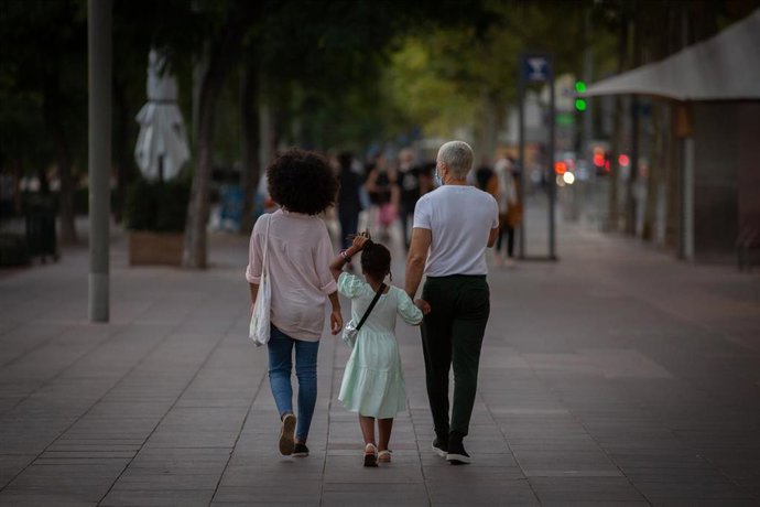 Dos padres con su hija paseando en Barcelona