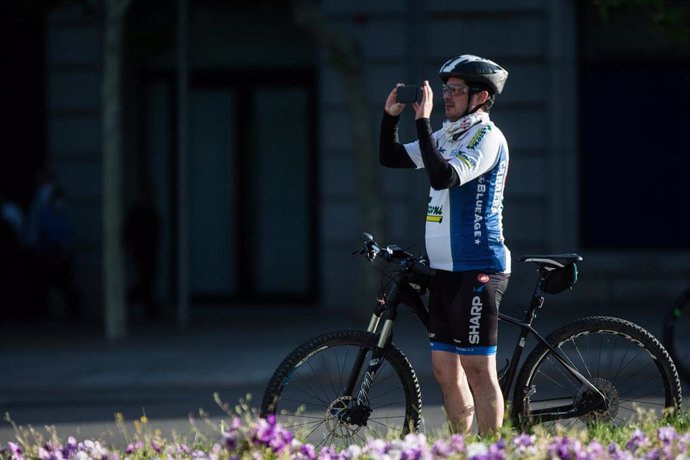 Un ciclista realiza una foto con el teléfono móvil