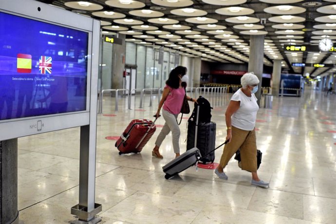 Dos passatgeres amb maletes en la terminal T1 de l'Aeroport de Madrid-Barajas Adolfo Suárez, a Madrid (Espanya).