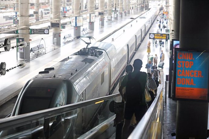 Varios pasajeros acceden al andén por una cinta mecánica en la estación Madrid-Puerta de Atocha