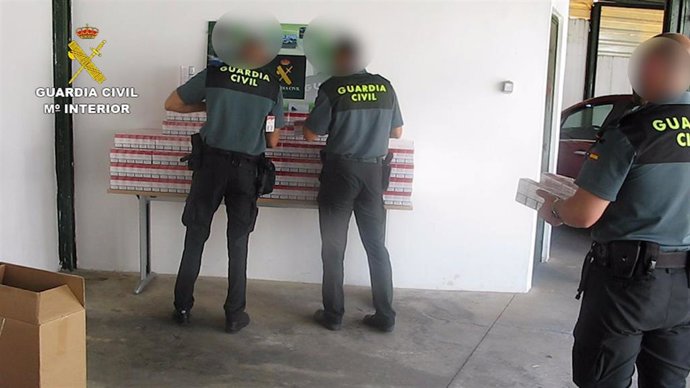 Agentes de la Guardia Civil colocan las cajetillas de tabaco de contrabando intervenidas.