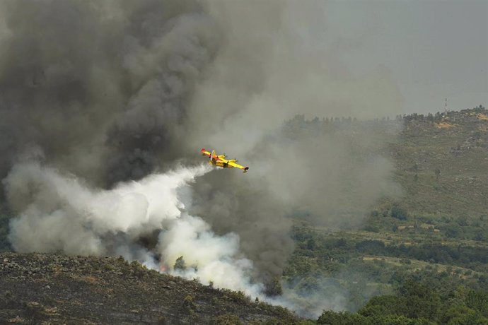 Un avión apaga fuegos de la UME sobrevuela y vierte agua sobre el incendio de Cualedro (Ourense).