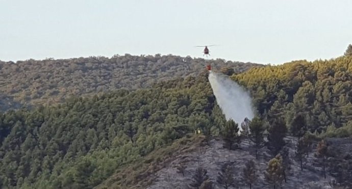 Imagen de descarga de agua de un helicóptero que trabaja en tareas de extinción de un incendio declarado en Olvera (Cádiz)