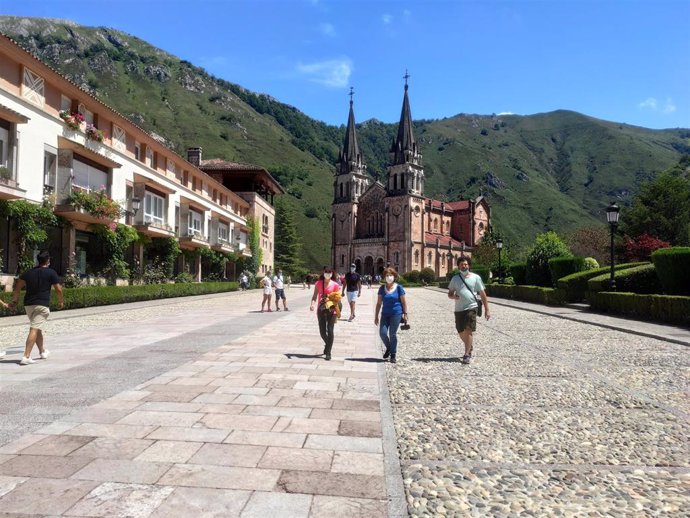 Gente paseando por la recientemente acondicionada explanada del Santuario de Covadonga con mascarillas.