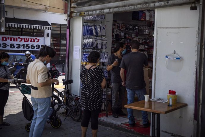 Un grupo de personas espera para entrar en una tienda durante la pandemia de coronavirus en Israel