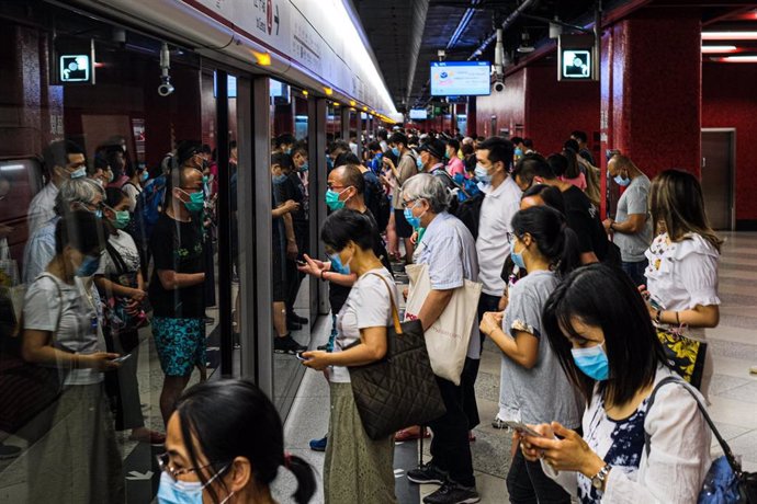 Usuarios del metro esperan para subirse a un vagón en Hoong Kong.