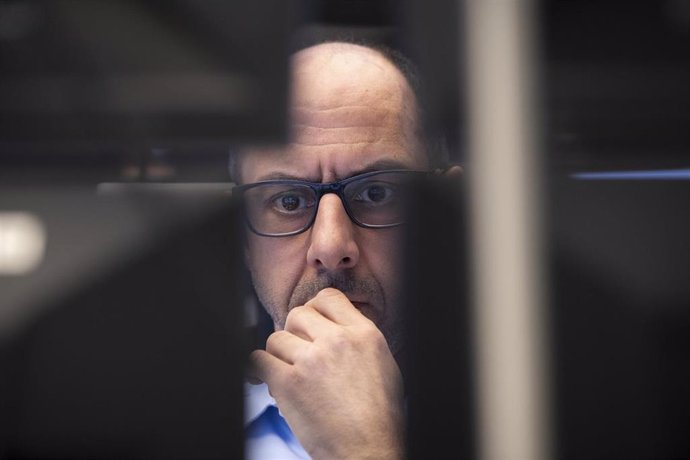 12 March 2020, Hessen, Frankfurt_Main: A stock trader looks at monitors in the trading room of the Frankfurt Stock Exchange. 