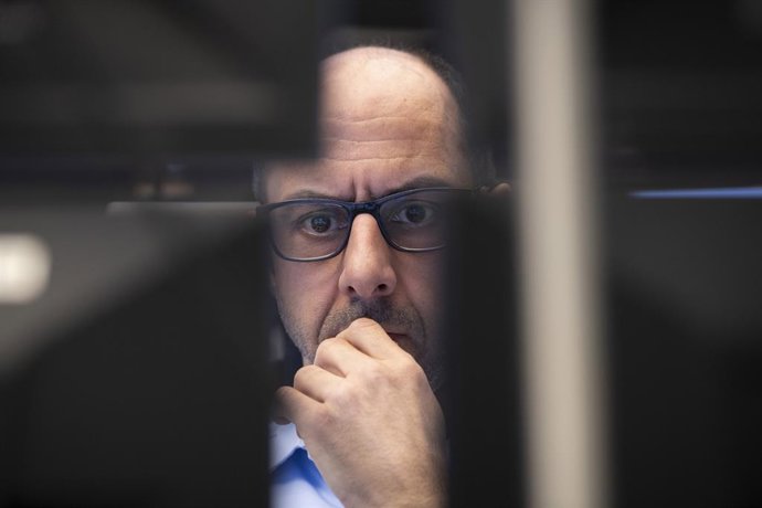 12 March 2020, Hessen, Frankfurt_Main: A stock trader looks at monitors in the trading room of the Frankfurt Stock Exchange. 