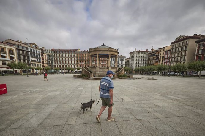 Un hombre con mascarilla pasea por la Plaza del Castillo de Pamplona