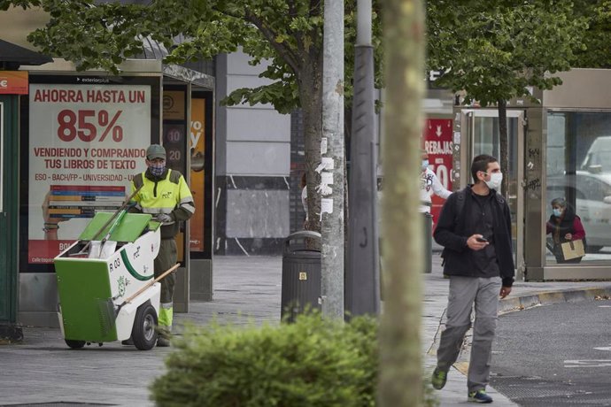 Un trabajador de limpieza y un ciudadano con mascarilla en Pamplona