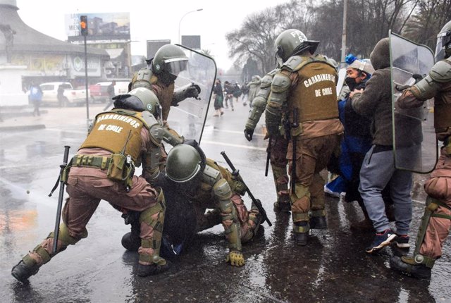 Carabineros detienen a personas en una manifestación mapuche contra la violencia de otros grupos. 