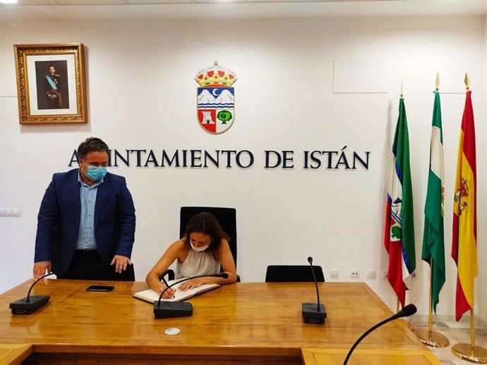 La delegada de la Junta en Málaga, Patricia Navarro, firma en el libro de honor de Istán junto al alcalde, José Miguel Marín.
