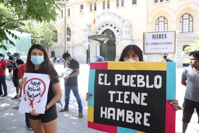 Una joven sostiene una pancarta donde se puede leer "El pueblo tiene hambre" durante una manifestación de las entidades ciudadanas que están dando respuesta a las 'colas del hambre' ante el Palacio de Cibeles.
