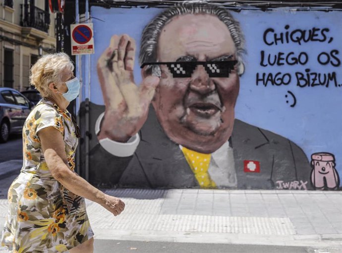 Una mujer pasa junto al grafiti del rey emérito Juan Carlos I pintada por el artista J. Warx, en Valncia