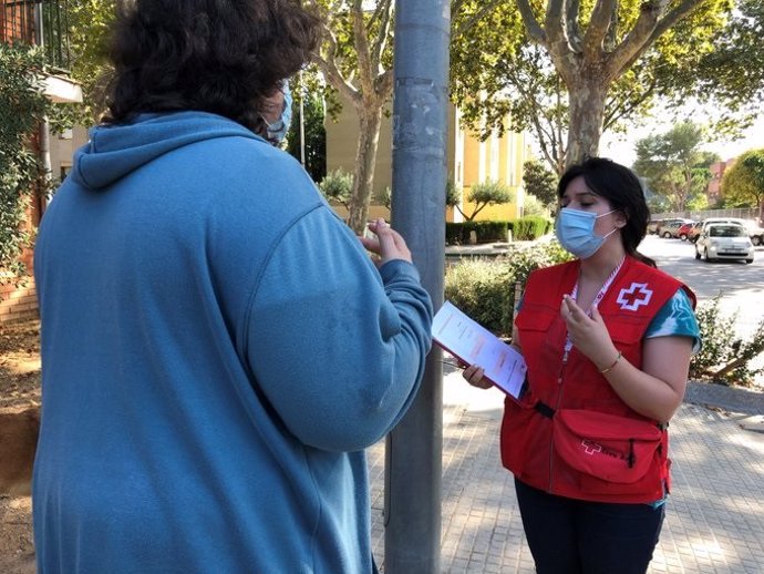 Una voluntria de Creu Vermella de Sabadell, informa a un vianant