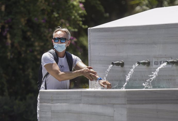 Un hombre se refresca en una fuente durante la ola de calor africano que ha llegado este jueves a España. En Sevilla (Andalucía, España), a 30 de julio de 2020.