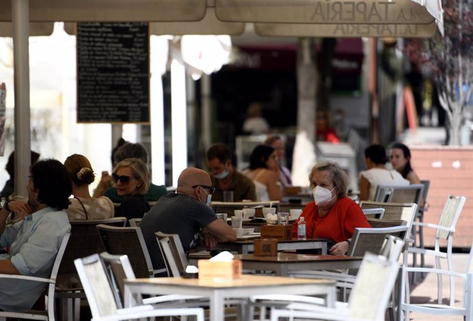 Varias personas disfrutan en una terraza de un bar el día en el que entra en vigor en la Comunidad de Madrid la ampliación del uso obligatorio de la mascarilla.