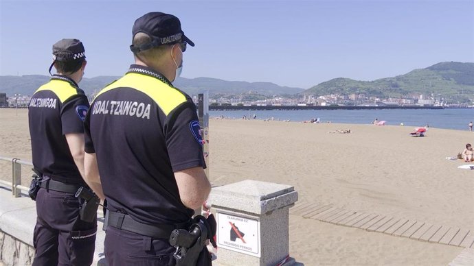 Dos agentes de la Policía Municipal de Getxo (Bizkaia)  vigilan la playa de Ereaga.