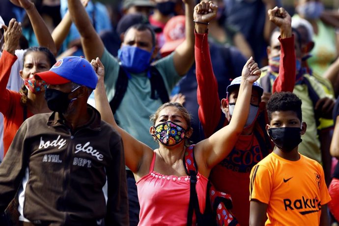 Trabajadores del mercado informal cercano a la Plaza de Toros Monumental de la ciudad venezolana de Valencia protestan por el cierre del las instlaciones por parte de las autoridades debid el aumento en el número de casos del nuevo coronavirus.