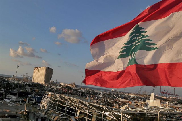 Una bandera de Líbano ondea junto a la zona destruida por la explosión en Beirut