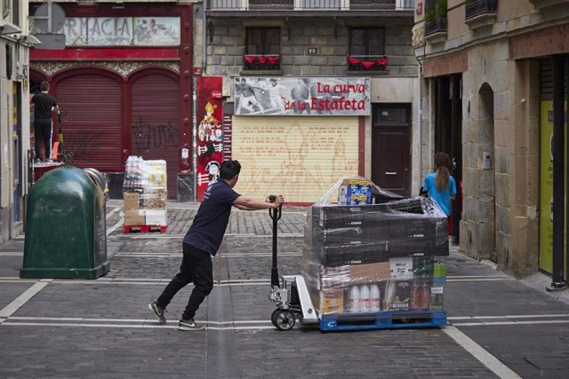 Un hombre arrastra un palé con productos en el casco antiguo de Pamplona