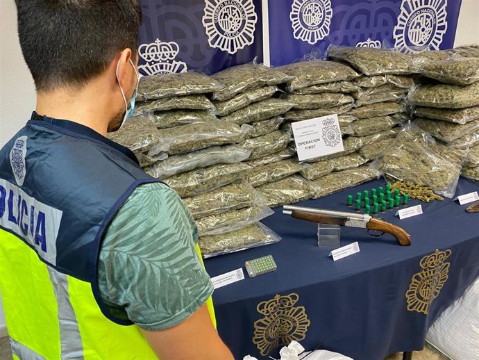 Un agente de la Policía Nacional junto a los efectos intervenidos en la operación First, con cuatro detenidos de una red que envasaba marihuana al vacío para venderla en el extranjero