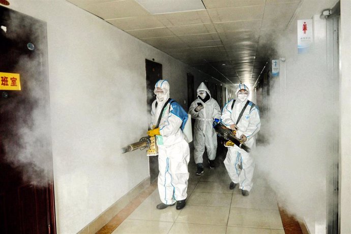 Voluntarios del servicio de salud público desinfectan un área de oficinas sitada en la provincia de Shandong, en el este de China, en el marco de la lucha contra la pandemia del nuevo coronavirus.