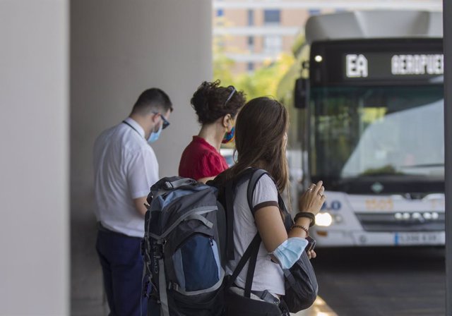 Varias personas en la parada del bus exprés hacia el aeropuerto. En Sevilla,  (Andalucía, España), a 31 de julio de 2020.