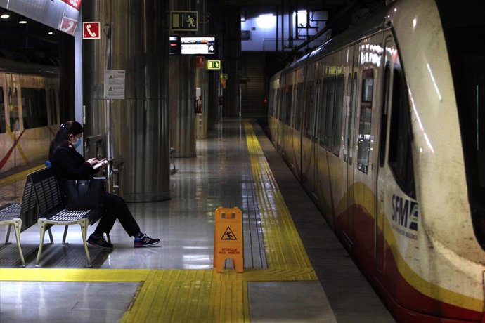 Una mujer protegida con mascarilla espera la llegada del metro en la estación Intermodal.