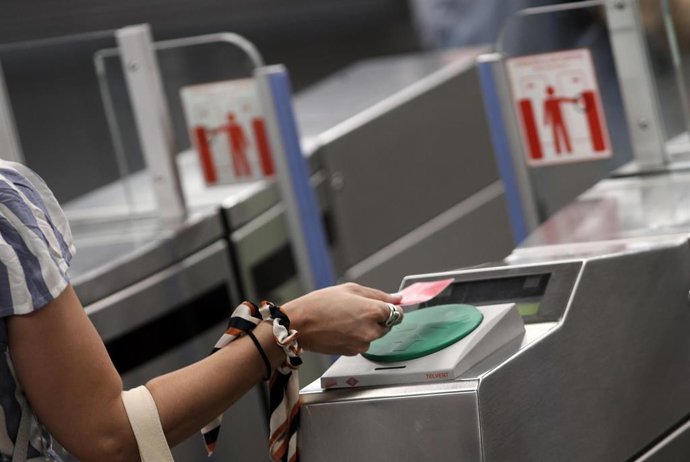 Una mujer pasa su billete en el torno del Metro Plaza de España, en Madrid (España), a 6 de julio de 2020.